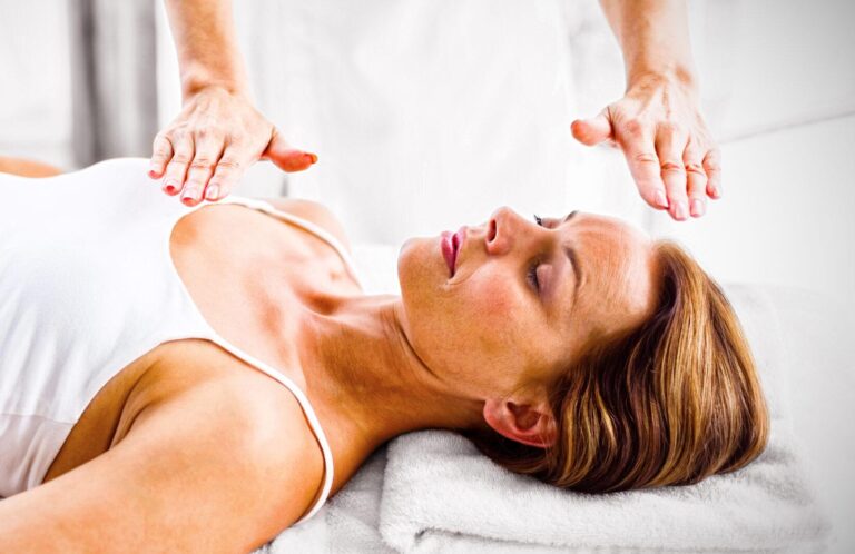 Woman receiving reiki treatment at spa